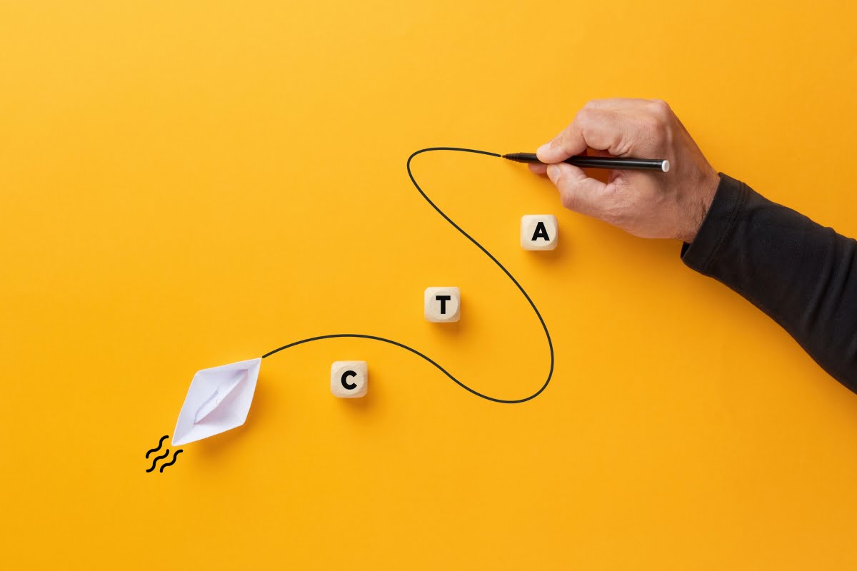 A man is drawing a paper airplane on a yellow background, showcasing his creative approach to convert traffic into sales.