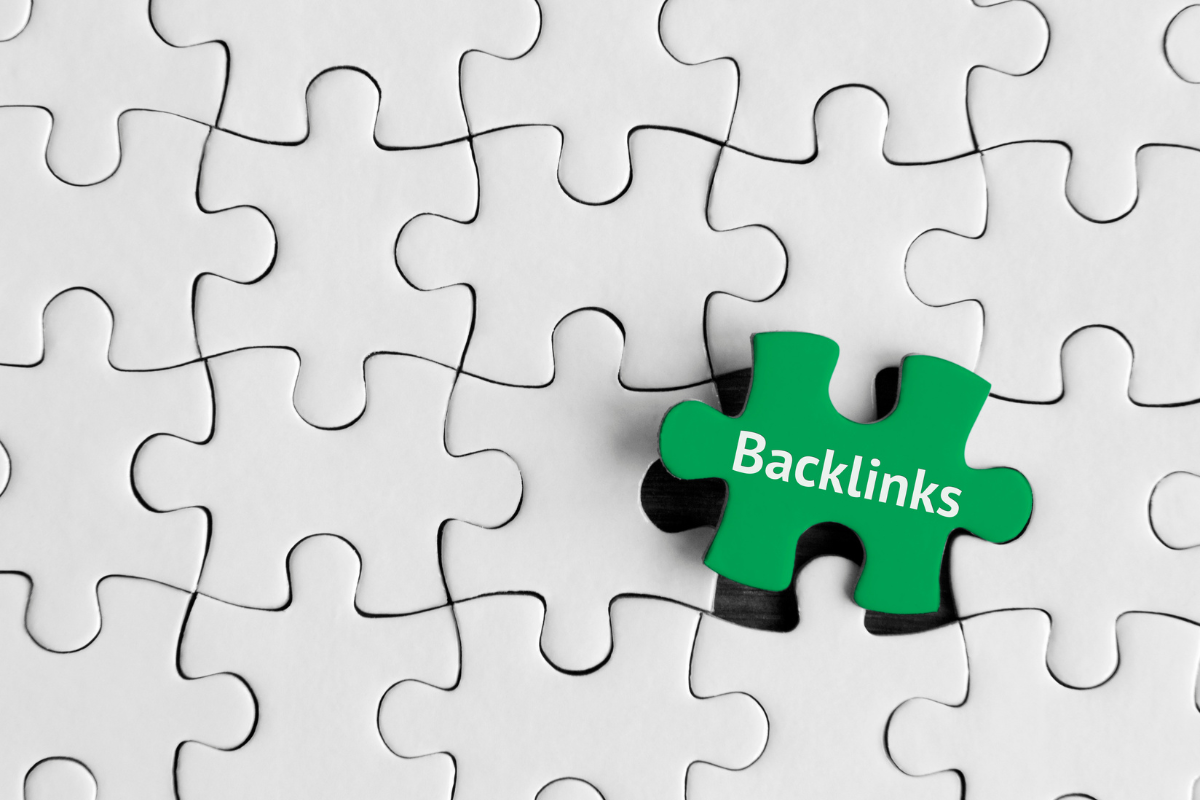 A green piece of jigsaw puzzle with the word backlinks, demonstrating how to generate quality backlinks.