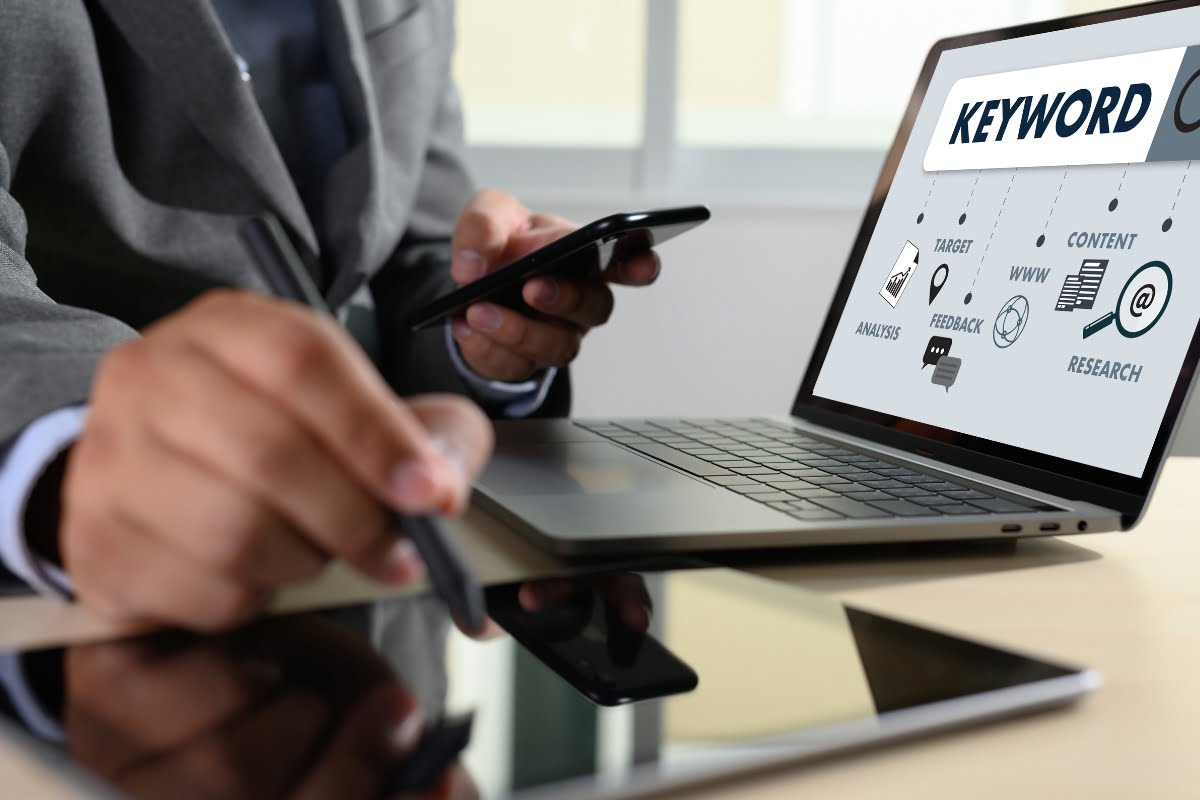 A businessman using a laptop with the word keyword clustering on it.