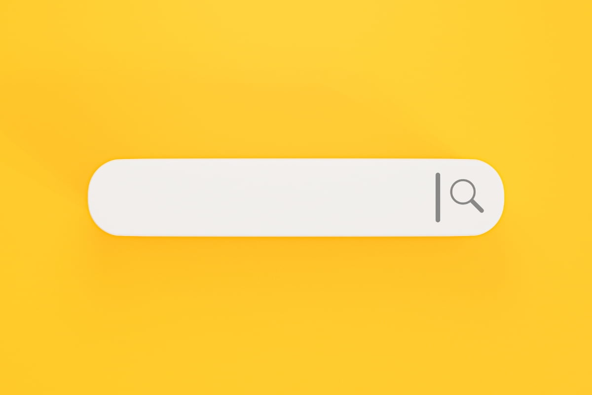 A white search bar on a yellow background with keyword clustering.