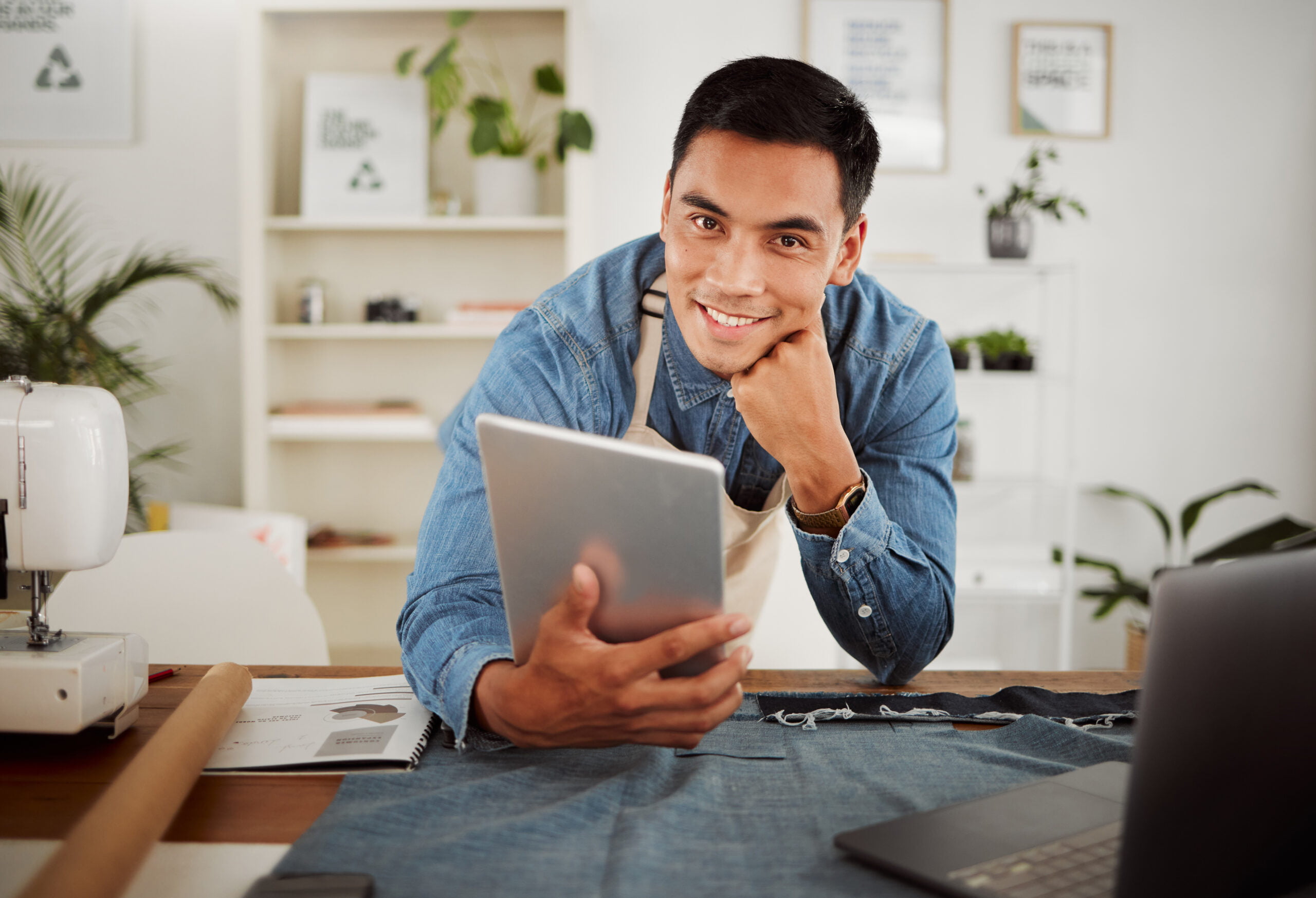 A business man sitting at a desk with a tablet computer.