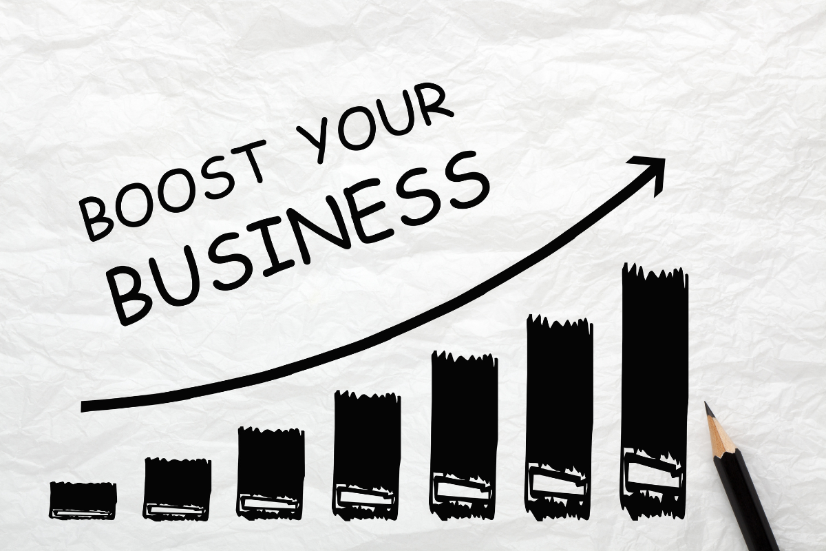 The phrase "boost your business" is drawn on a piece of paper.