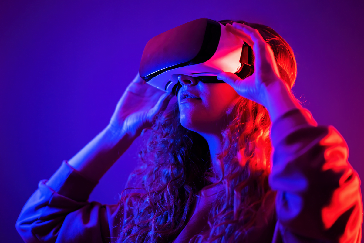 A woman wearing a VR headset in front of a purple background.