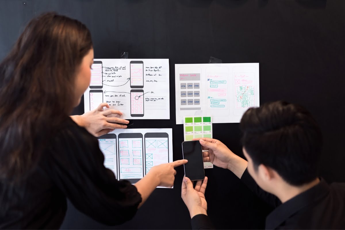 Two people, responsive wordpress themes, looking at a blackboard with notes on it.