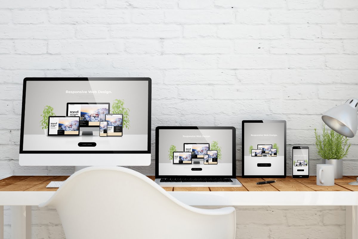 A white desk with a laptop and desktop computer.