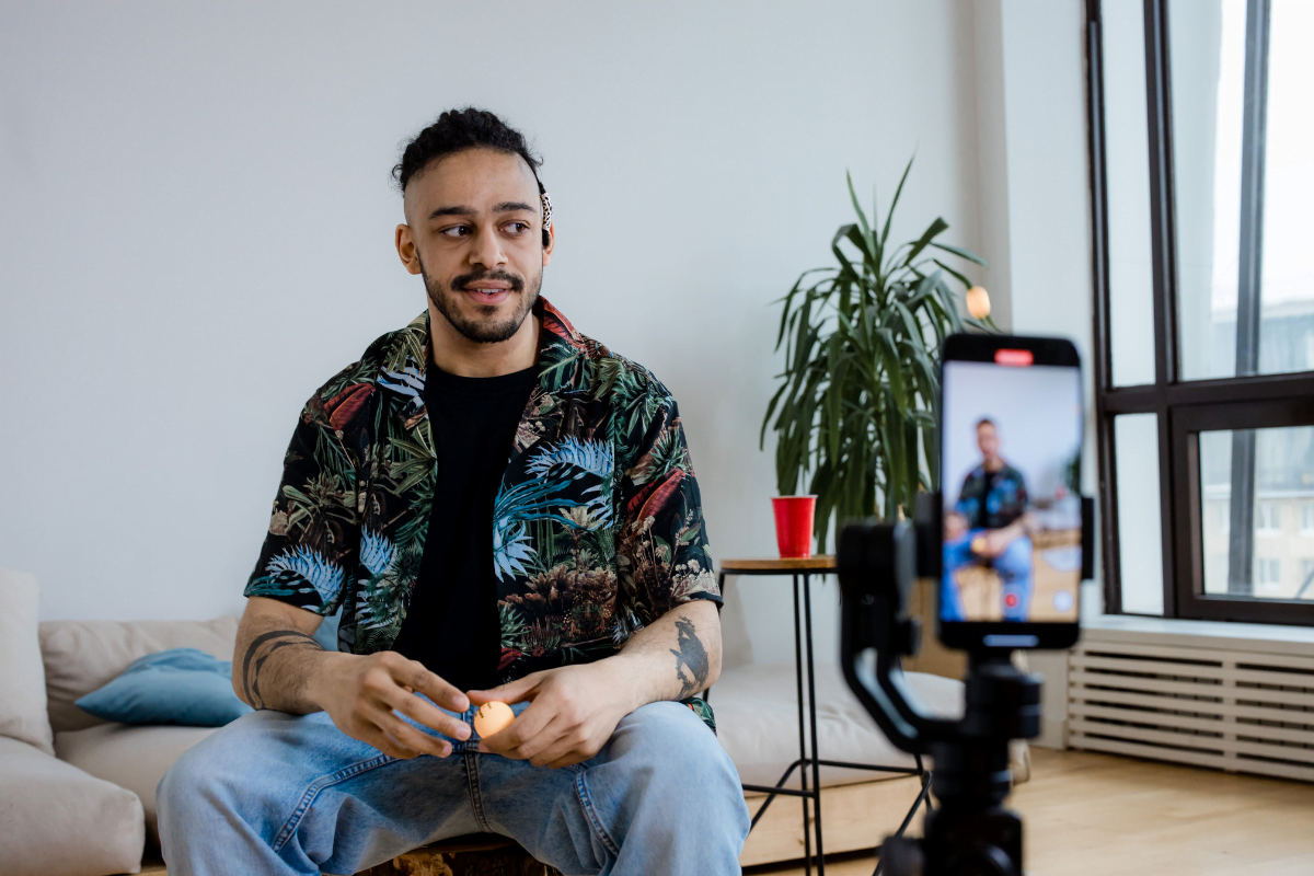 A man strategically filming short content in his living room using his phone.