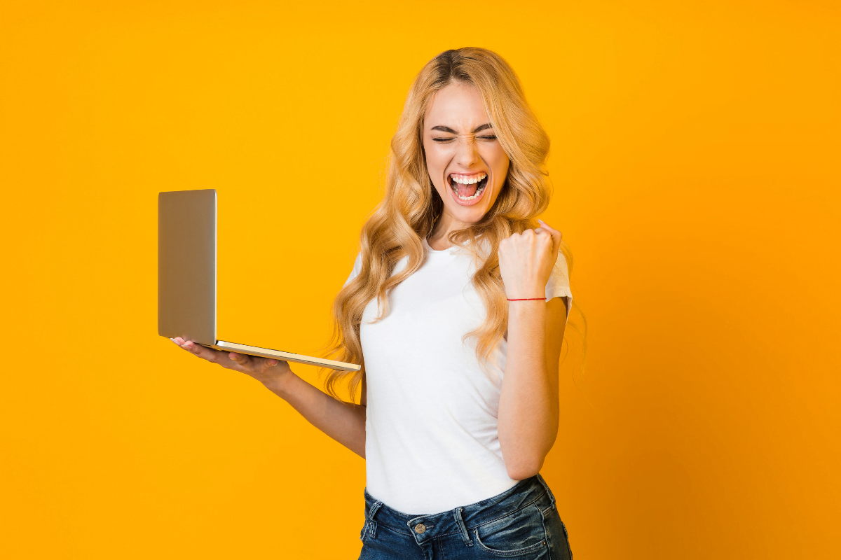 A woman winking while holding a laptop for a seamless website's user experience (UX).