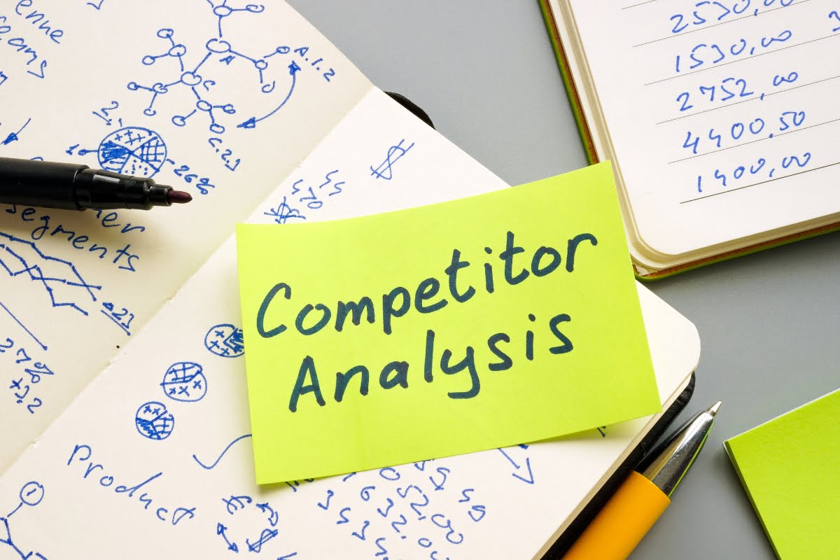 A sticky note with the words competitor analysis and website audit checklist on it.