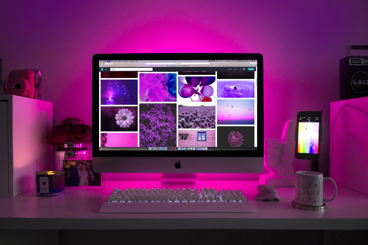 A desk with a monitor, keyboard, mouse, and a lamp suitable for website photos.