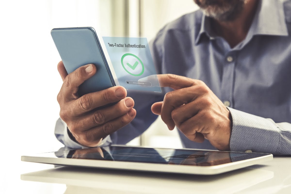 A man using a tablet to ensure WordPress security with a check mark on it.