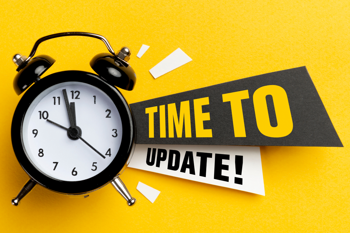 An alarm clock with the word "time to update" on a yellow background.