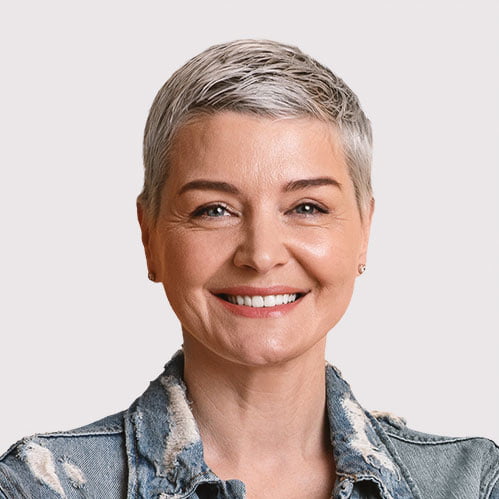 A woman wearing a denim jacket smiling.