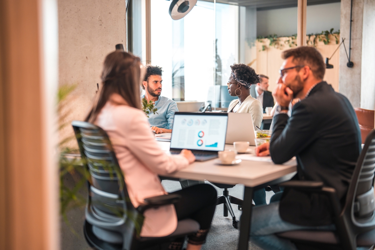 A group of people sitting around a table in an office discussing the best local SEO company for their needs.