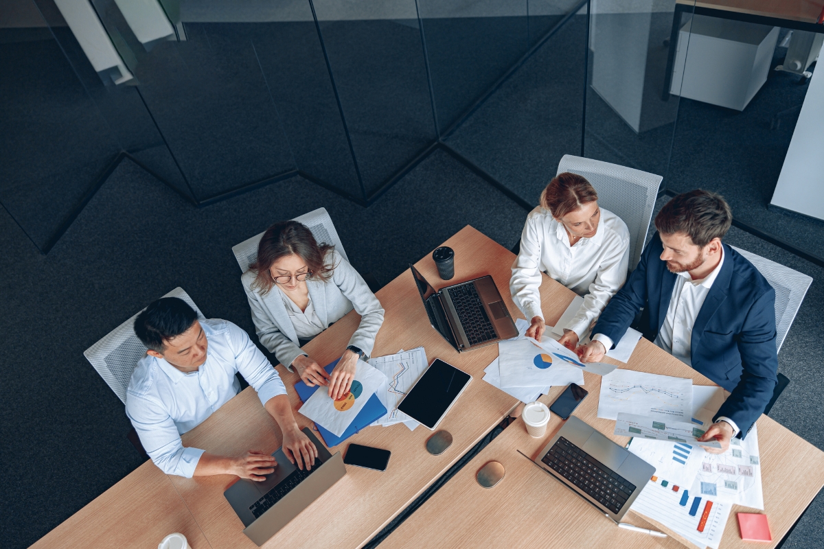 A group of people sitting around a table in an office discussing how to choose the best local SEO company.