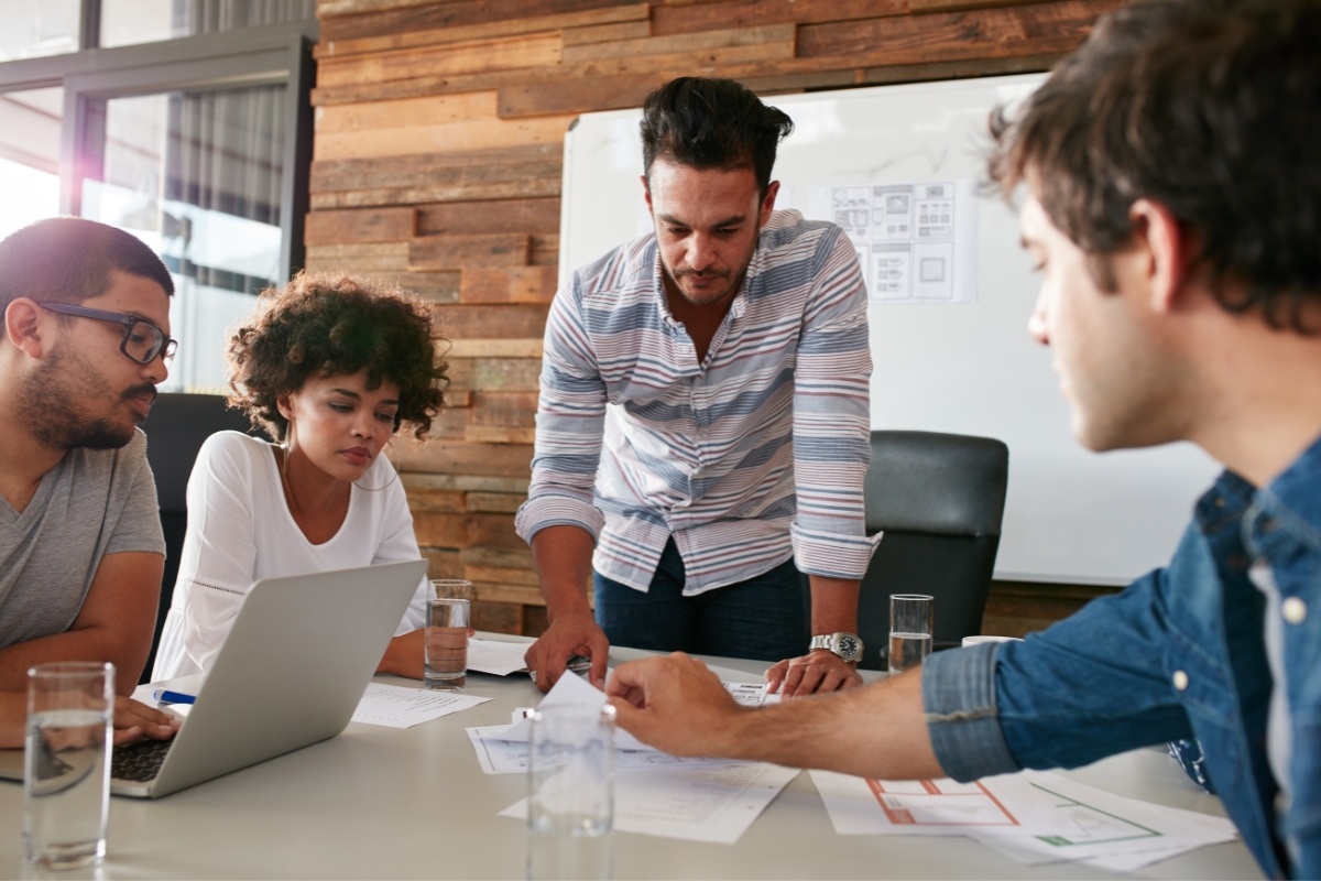 A group of people brainstorming ideas at a table in a meeting room on how to choose the best local SEO company.