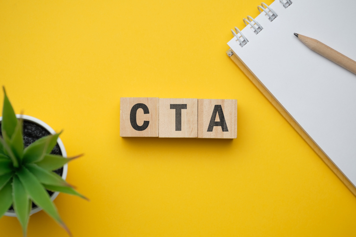 The word CTA on a sunny yellow background with a small plant nearby.