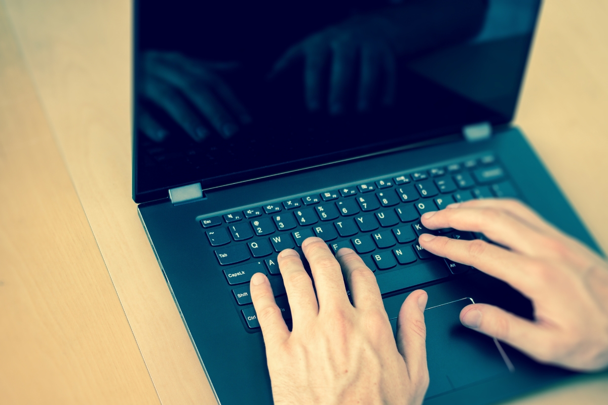 A person's hands typing on a laptop, seeking help with WordPress.