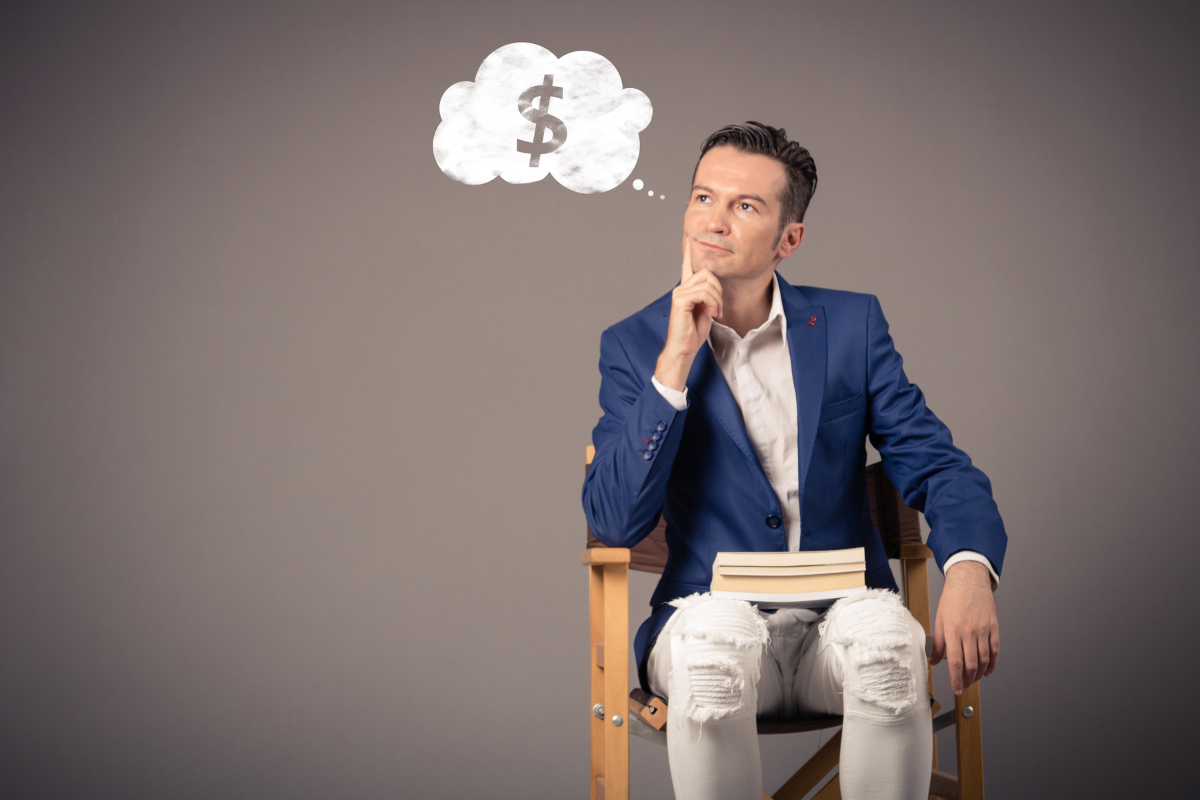 A man contemplating in a chair with a thought bubble over his head and a dollar sign.