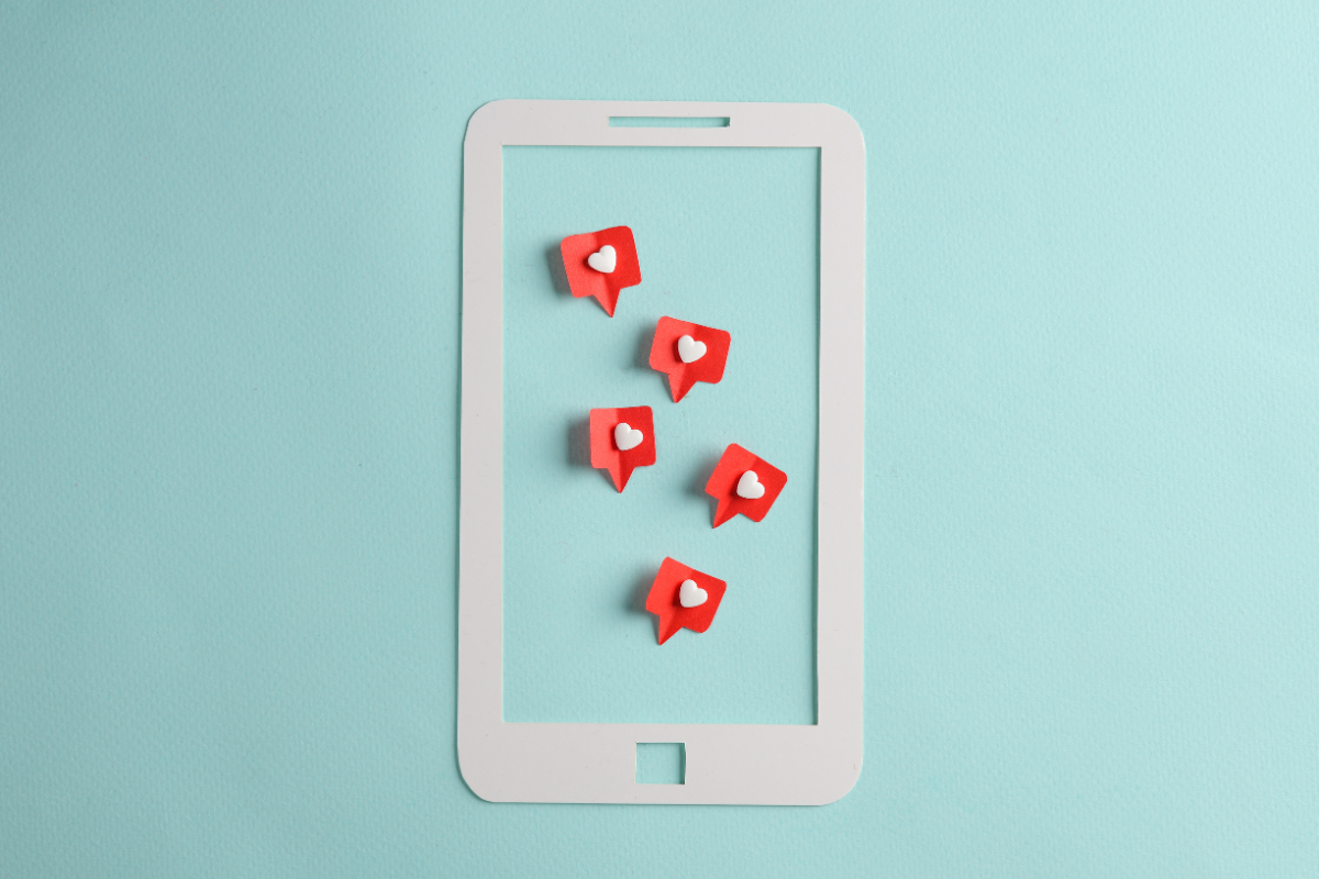 A white cell phone with red hearts on it, perfect for those looking to design a website with an integration of social media.