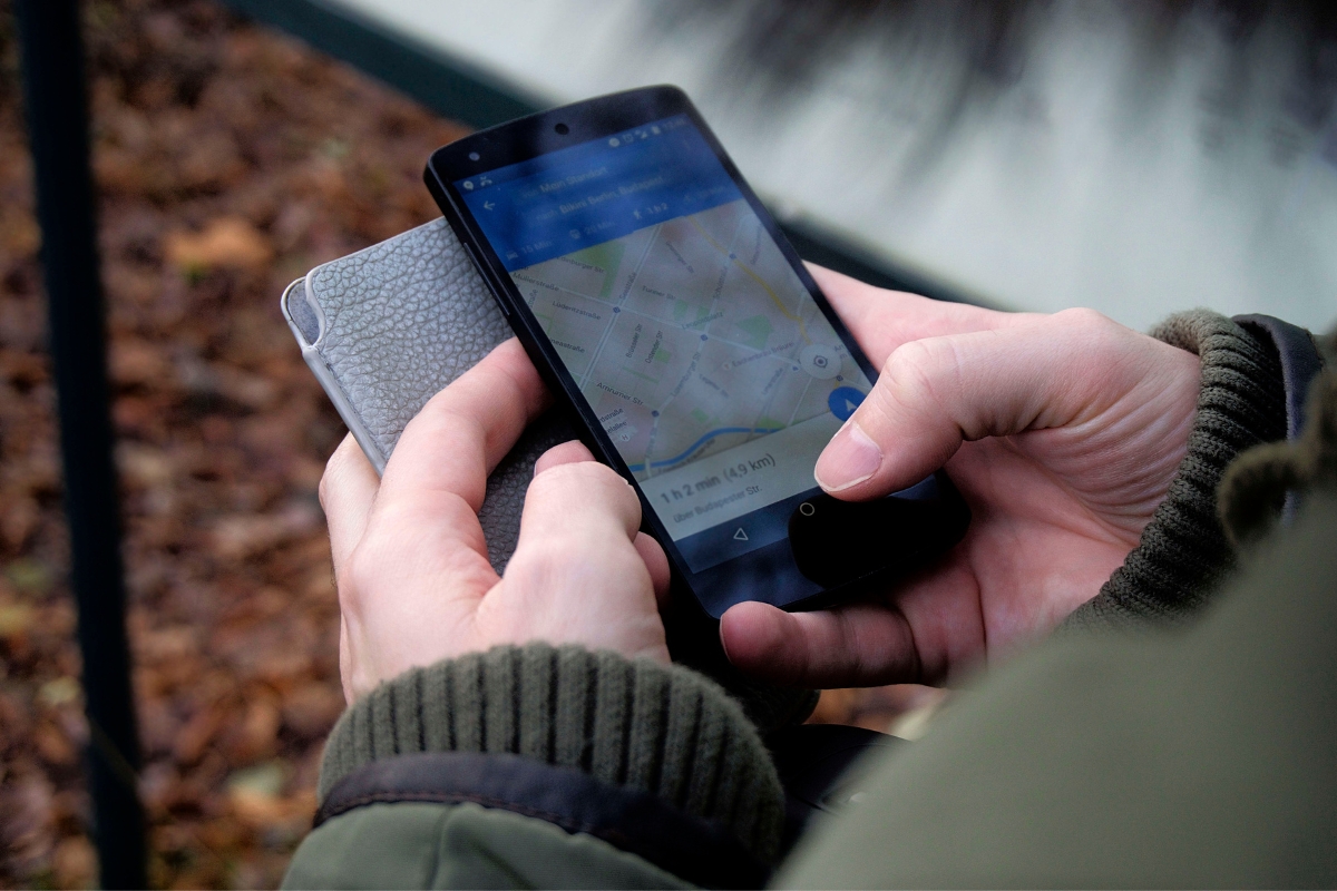 A person holding a cell phone with a map on it, learning how to rank on Google Maps.