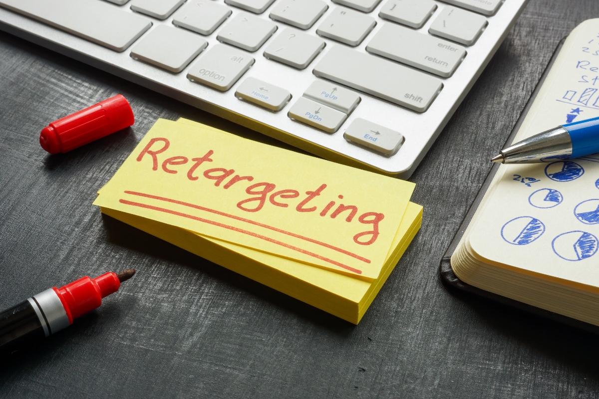 A sticky note with the word retargeting next to a keyboard and mouse at the marketing funnel stage.