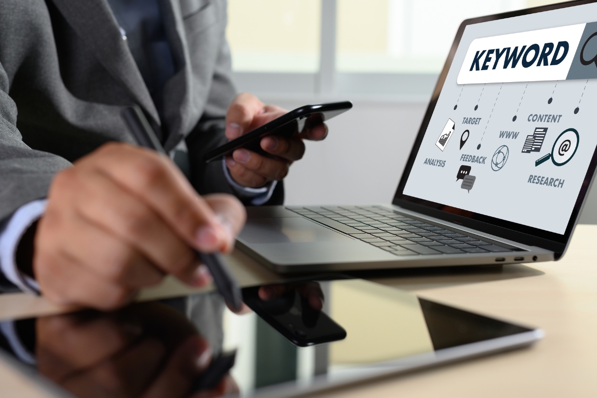 A businessman using a laptop with the word SEO on it.