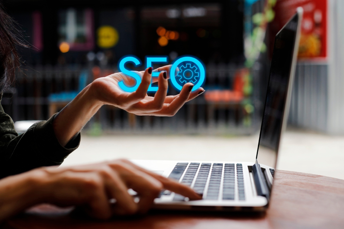 A woman is using a laptop with the word seo on it to improve performance.