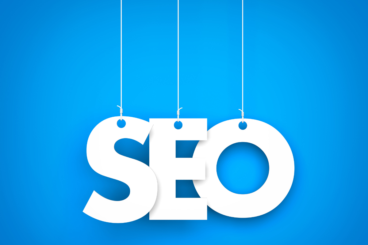 The word SEO hanging from strings on a blue background.