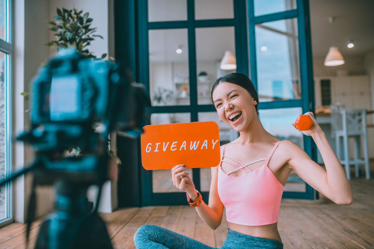 A woman holding an orange sign with the word "giveaway."