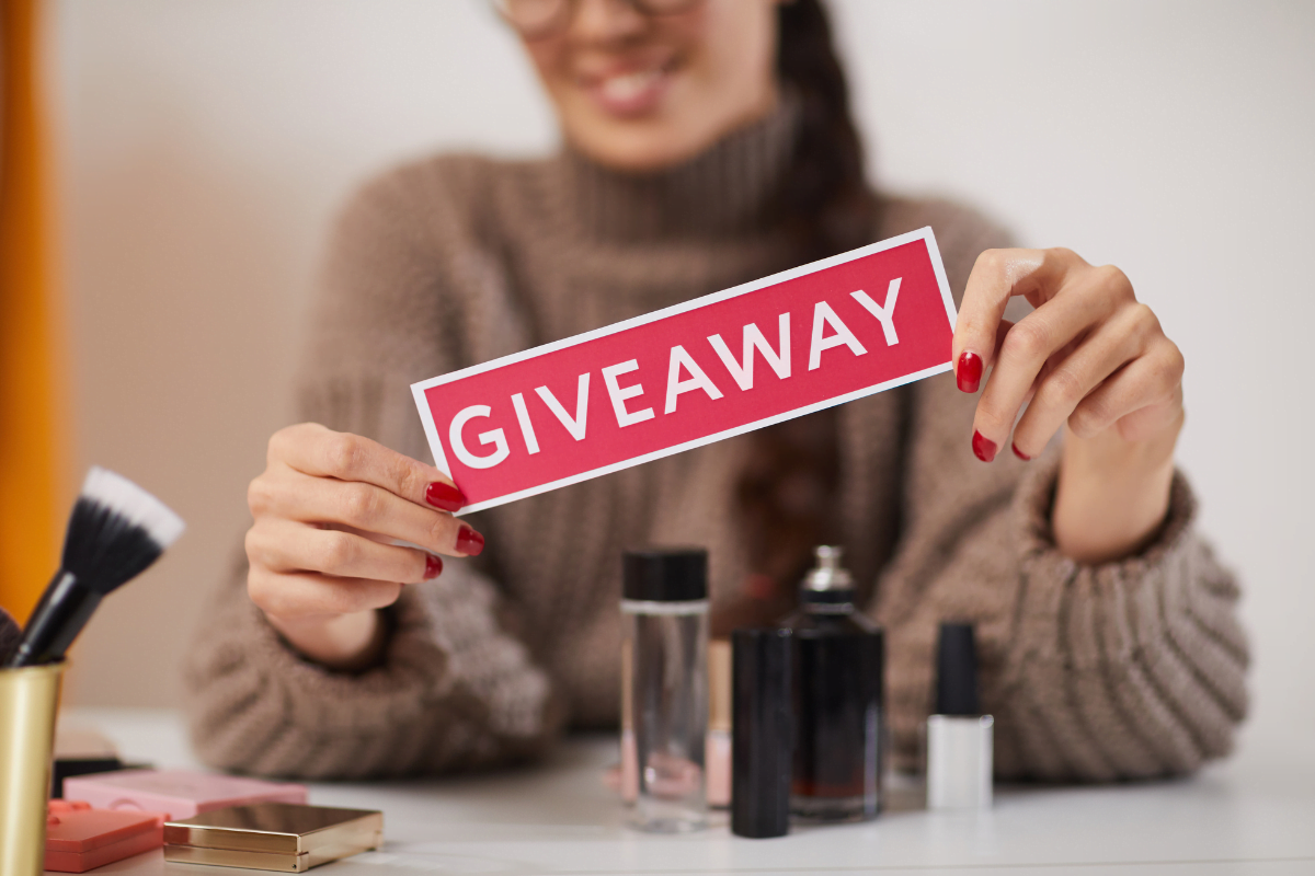 A woman holds a sign with the word giveaway.