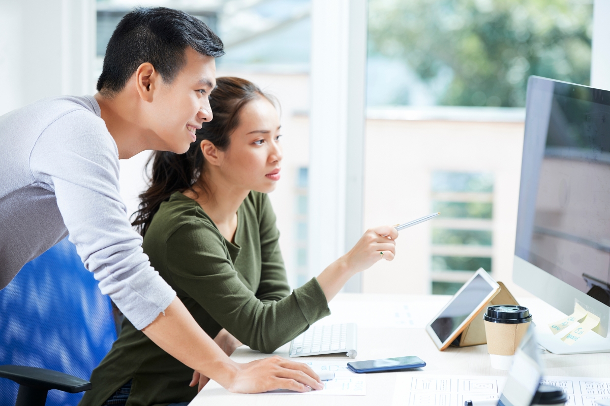 A couple browsing a computer screen to understand the purpose of a website.