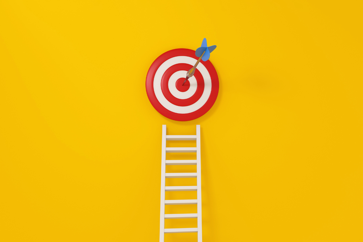 A ladder on a yellow background with a target on it.