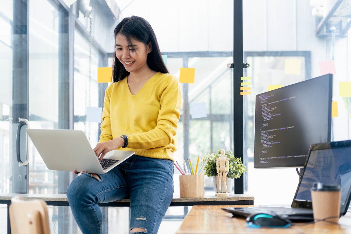 A woman working on code minification on a laptop in an office.