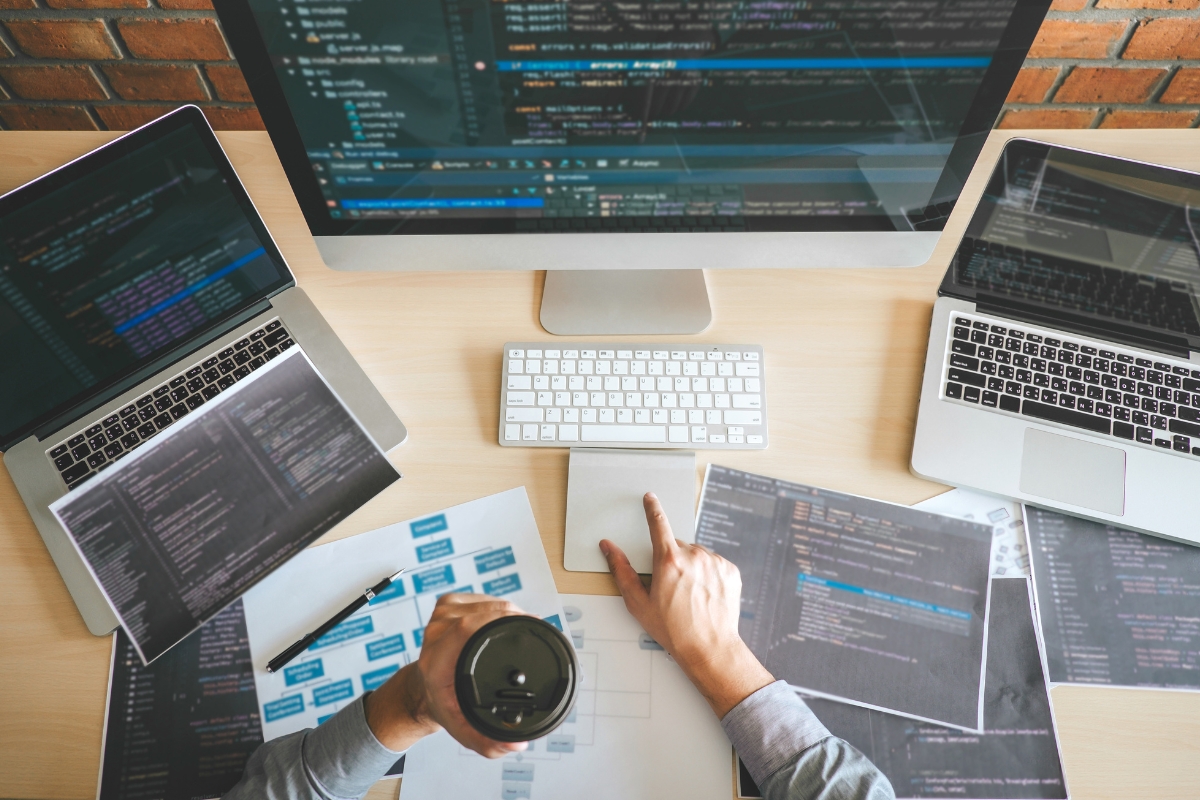 A man is working on code minification with a cup of coffee.