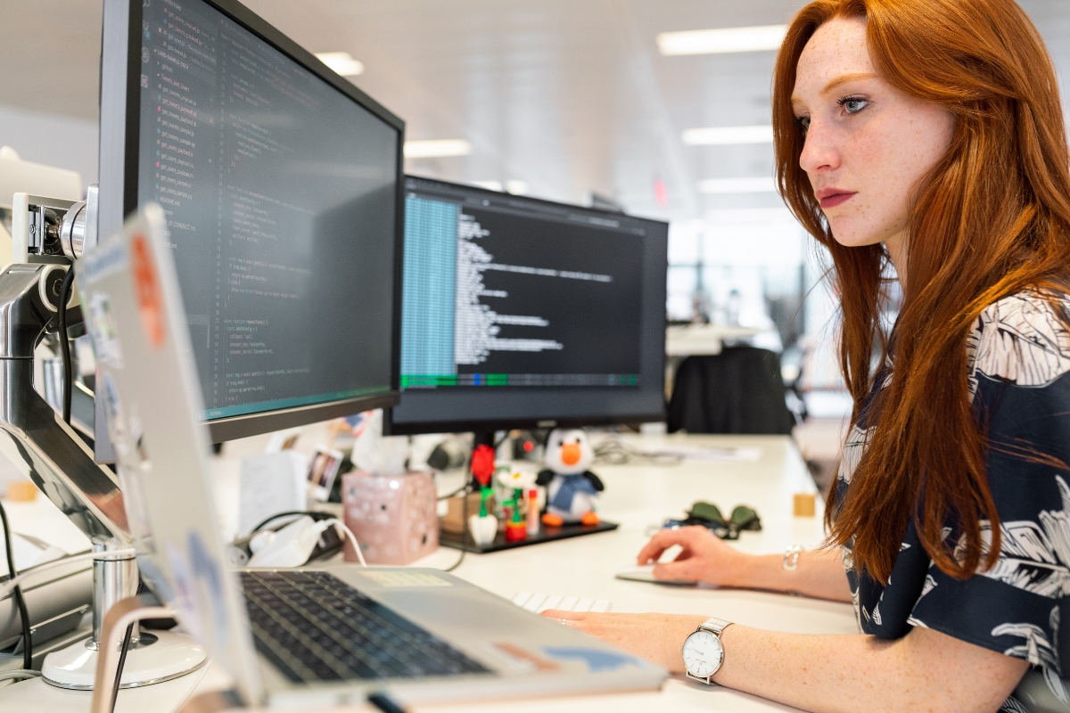 A woman working on code minification on a computer in an office.