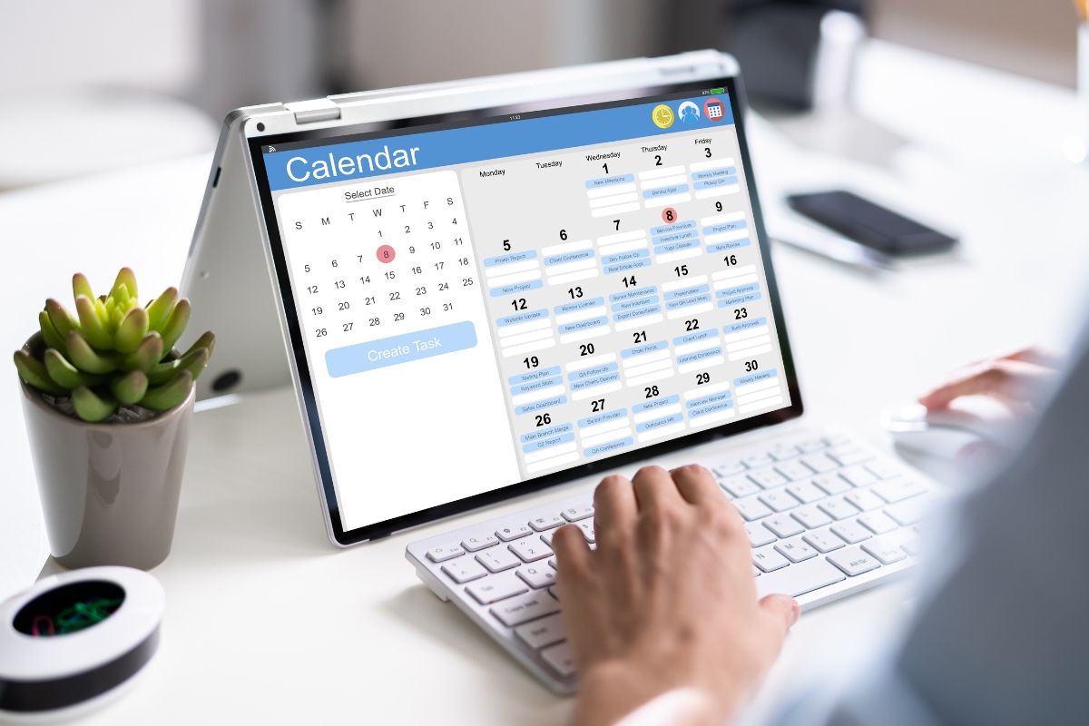 Person working on a computer with a content calendar application open on the screen.