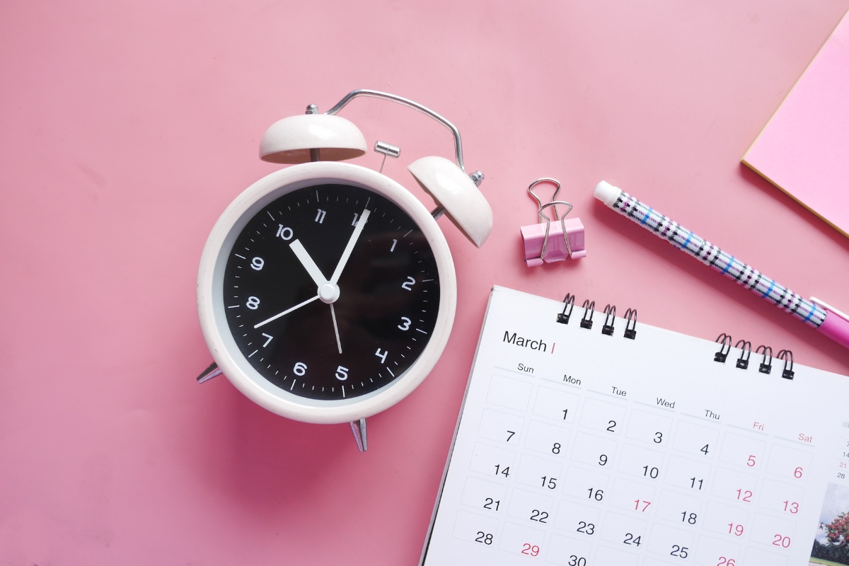 Analog clock showing 10:10 placed next to a content calendar on a pink background.