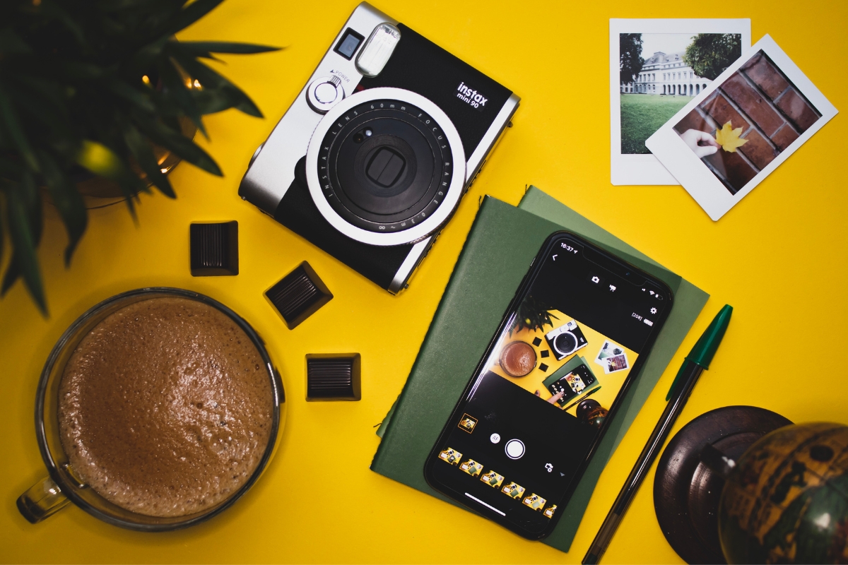 An instax camera and a cup of coffee on a yellow table, representing the casual, everyday moments targeted in conversion funnel marketing.