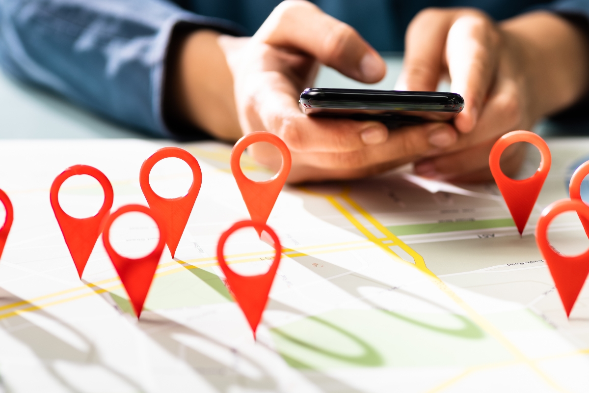 A person using a smartphone above a map with multiple red location markers indicating home service companies.