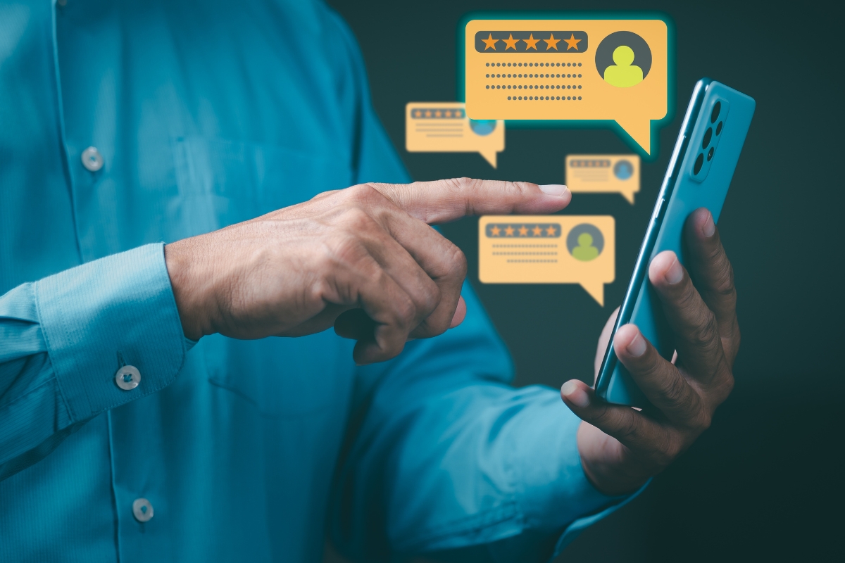 A man is pointing at a phone with a number of HVAC customer reviews on Facebook.