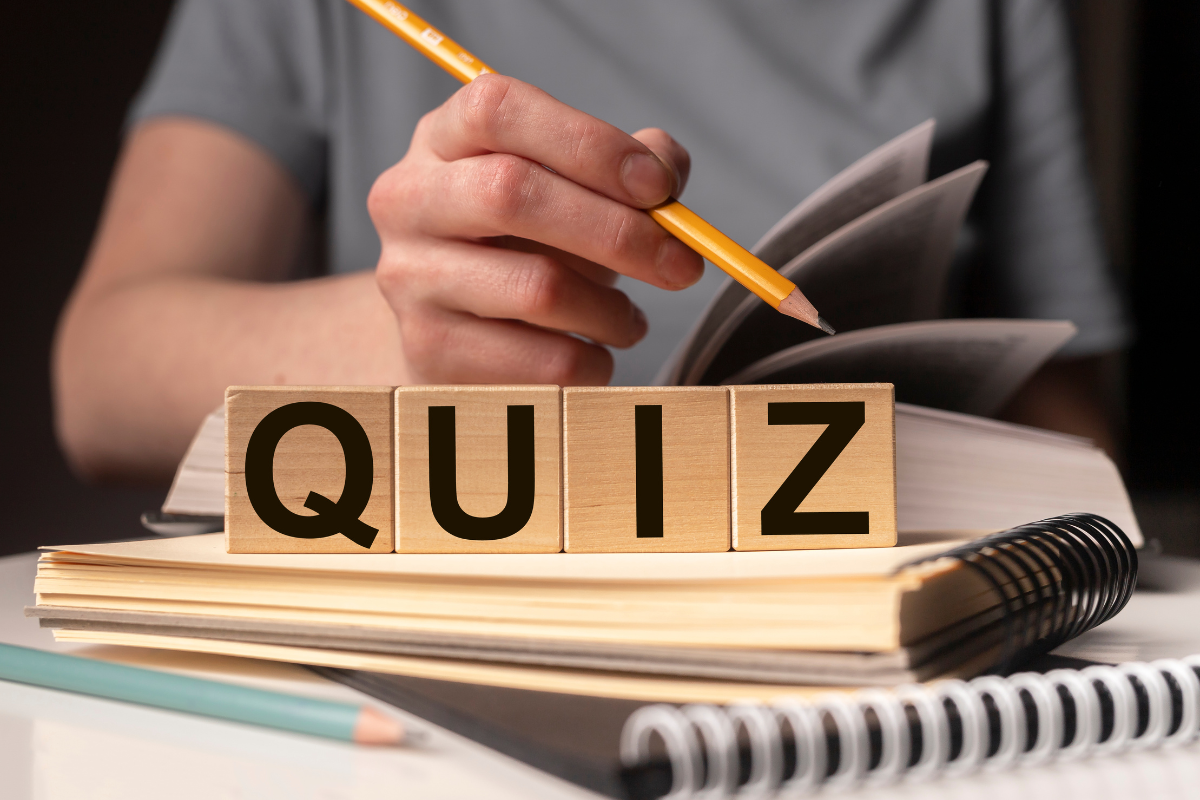 A person holding a book with the word quiz on it.