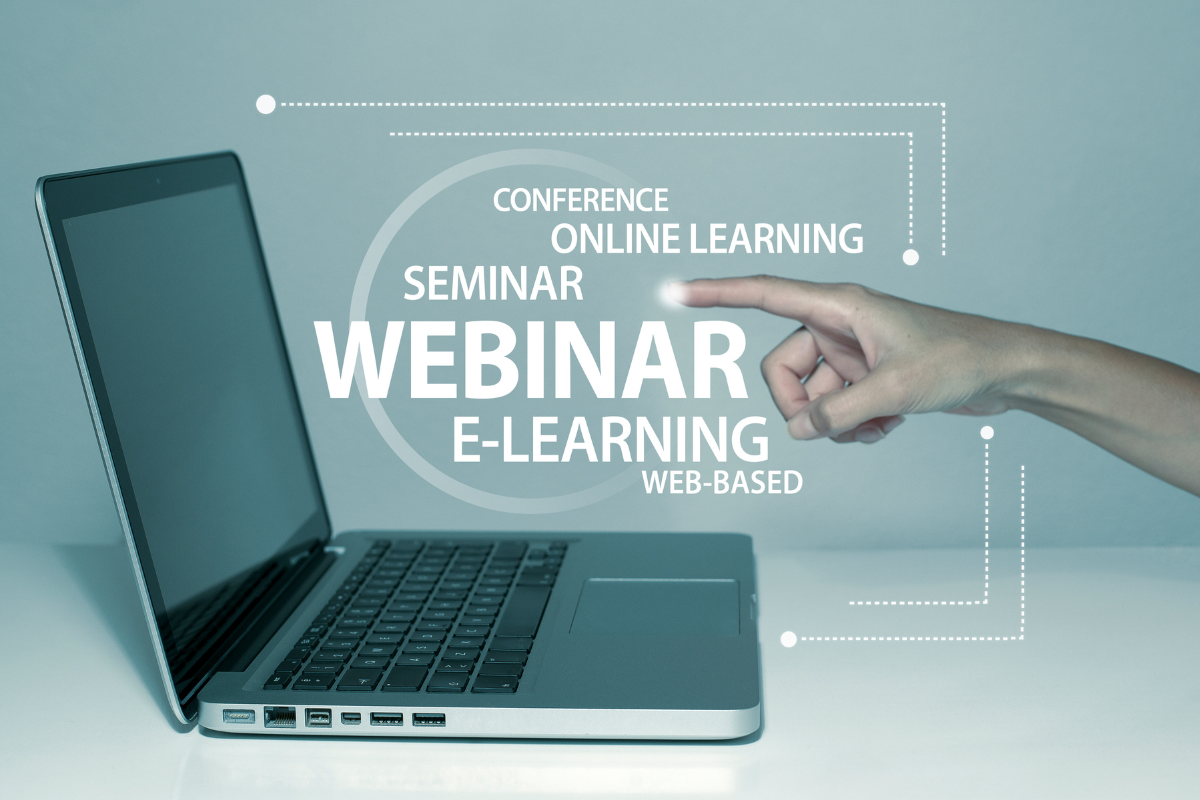 A person is pointing at a laptop with the word webinar for lead magnet ideas.