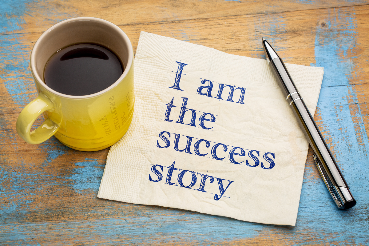 A paper with a pen and a cup of coffee and the phrase "I am the success story" on it.