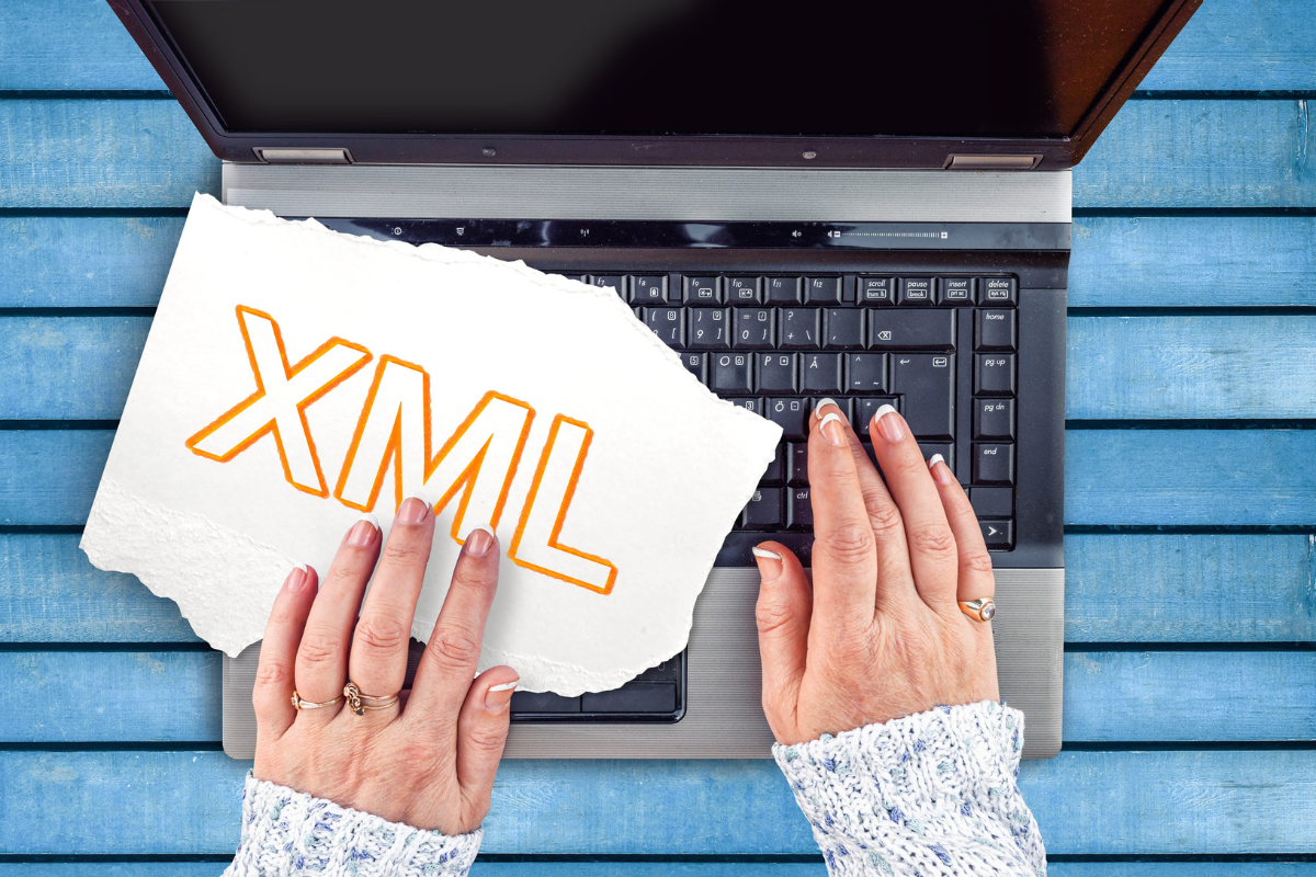 A person's hands on a keyboard with a piece of paper that says XML.