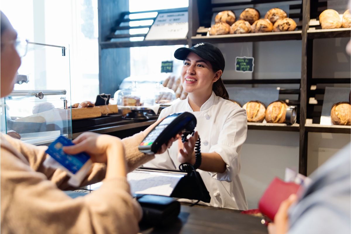 Cashier smiling at a customer while processing a payment at a local business using seo techniques for local seo