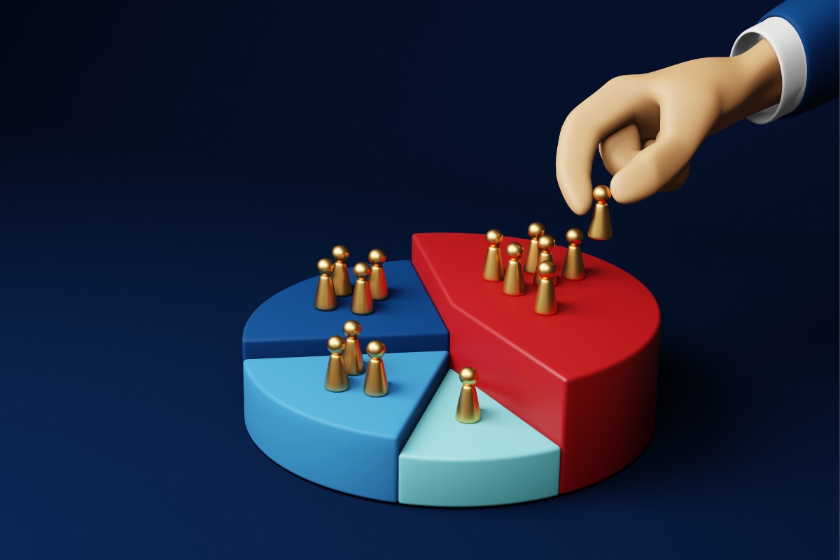 Hand placing a figure onto a red pie chart segment representing human resources or workforce allocation in service based business marketing.