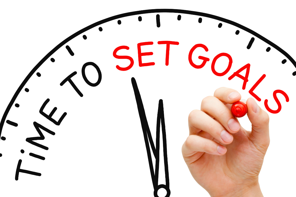 Person drawing a speedometer-style graphic indicating "time to set goals" with a marker.