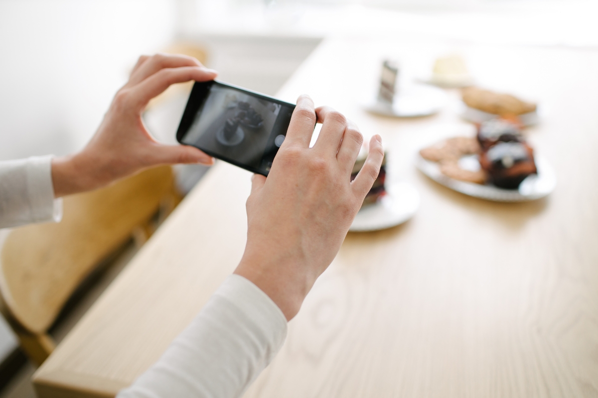 Person taking a photo of food with a smartphone for small business marketing ideas.