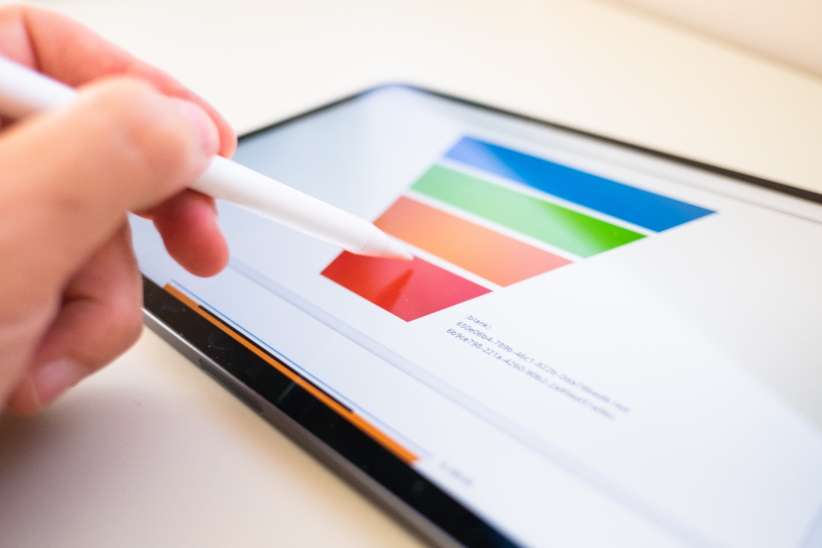 A person holding a pen on an iPad, illustrating what is a sales funnel on it.