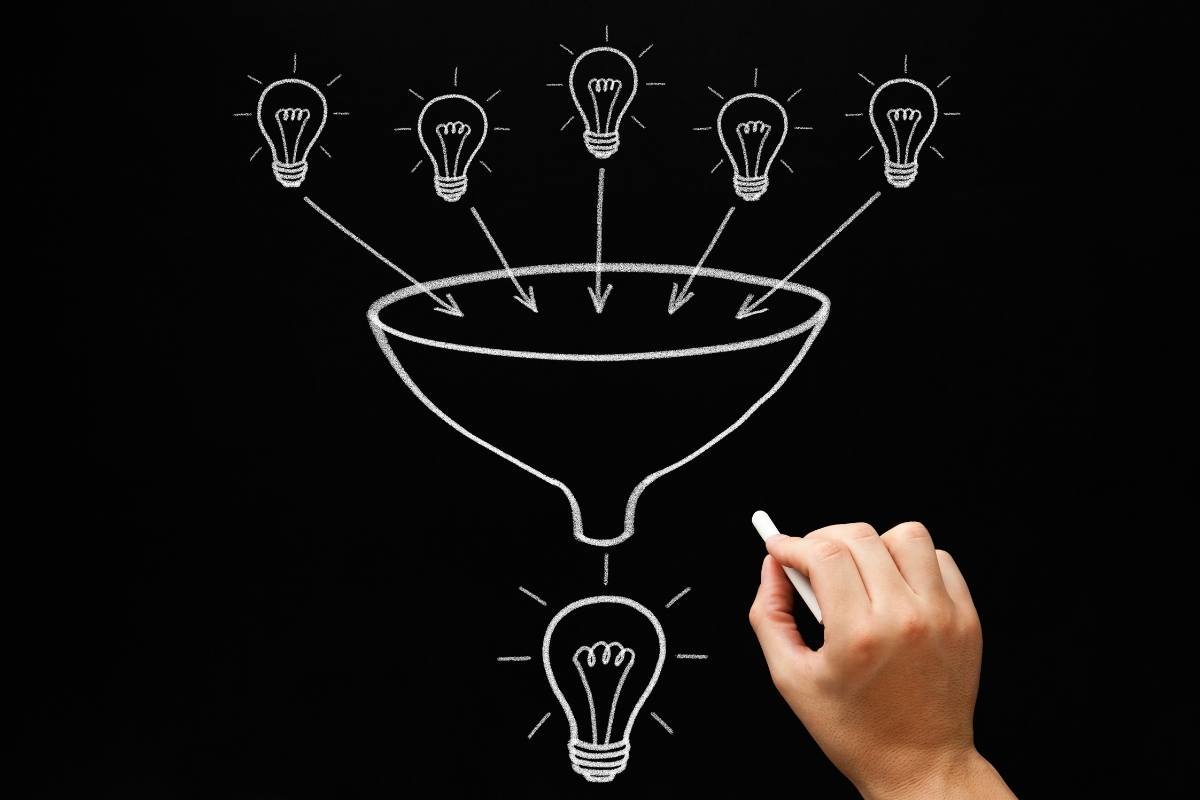 A hand drawing what is a sales funnel with light bulbs on it.